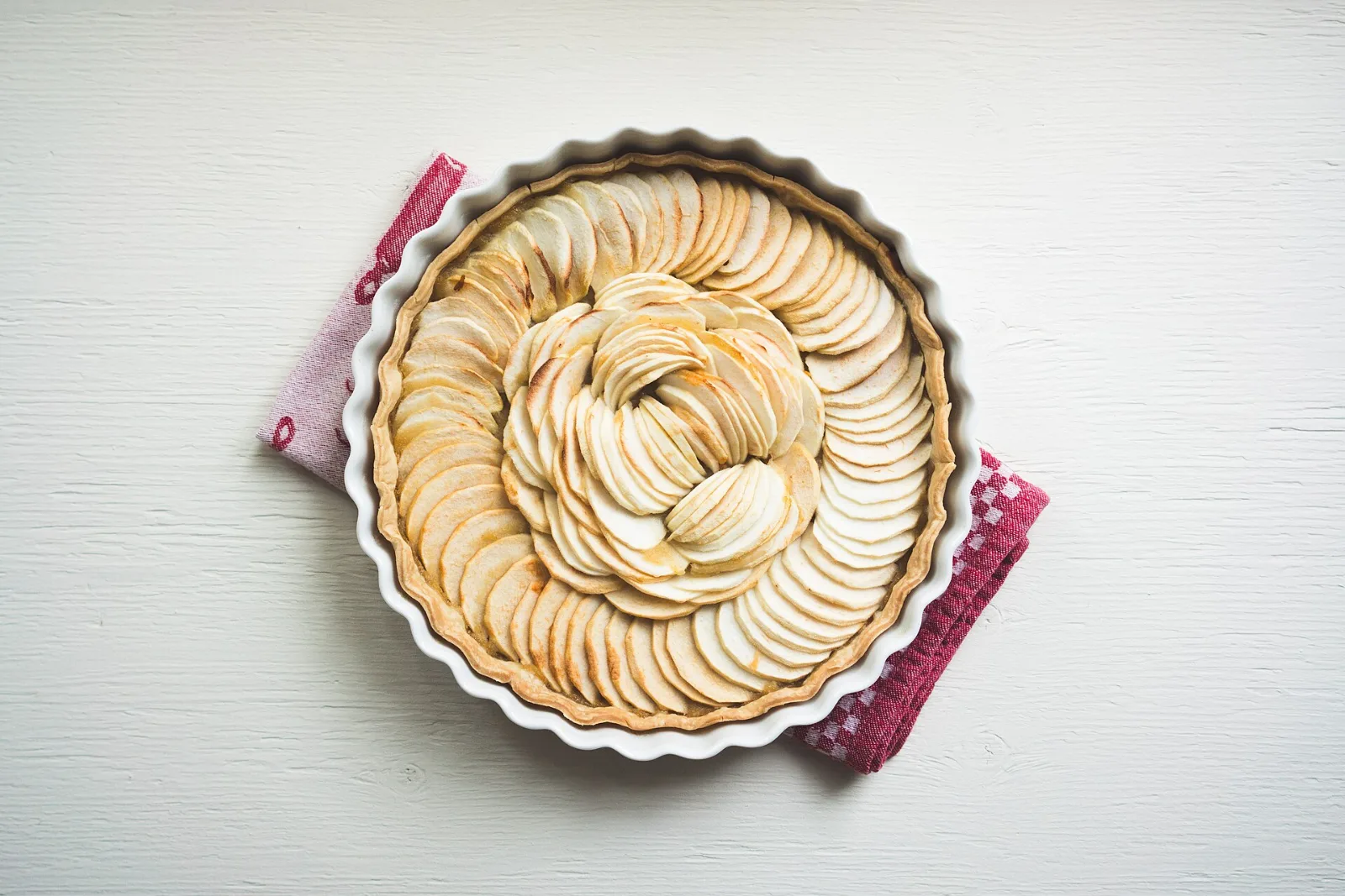 An apple tart seen from above, its slices fanned in a spiral